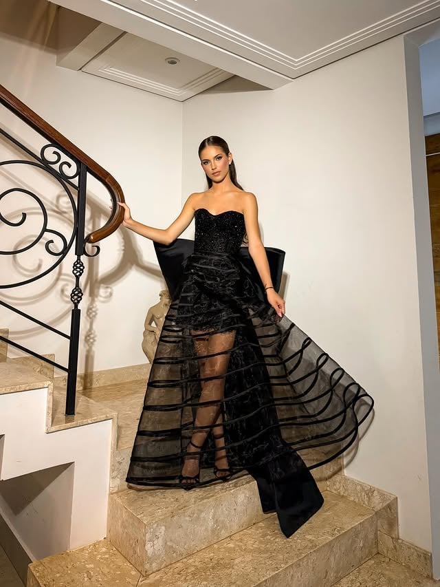 #NoirÉtoile 🖤A intensidade do preto ganha ainda mais destaque nessa criação imponente e sofisticada!O vestido em crinol traz movimento e leveza através das faixas horizontais transparentes, criando um efeito moderno e marcante. O corpete sem alças, totalmente bordado com pedrarias diversas, ilumina a peça com brilho refinado, enquanto o máxi laço transforma o visual em uma composição fashionista e cheia de personalidade.Uma criação pensada para debutantes que desejam elegância, presença e um visual inesquecível para os 15 anos! ✨Maquiagem @lorakmakeup Cabelo @karina_ramirezpenteados Modelo @juliap.amaral Fotógrafo | Videomaker @renatoleite_Acessórios @patiolie.acessorios #PatiOlie #AltaCostura #VestidoPreto #FeitoAMão by @patiolie