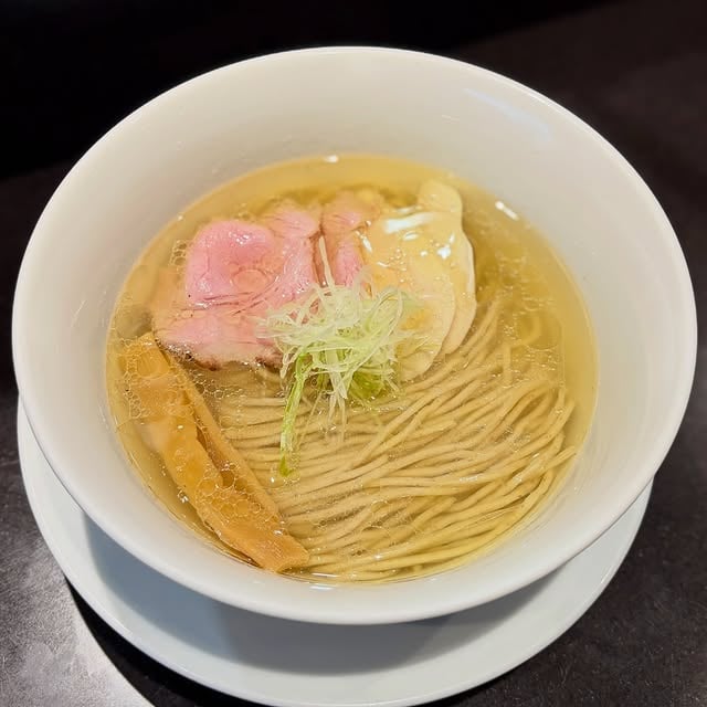🇰🇷
Shio Ramen at @menyajoon

Second visit to Menya Joon, was eager to come back after a very good first visit. Tried the standard Shio Ramen this time. The master here is a @menya.sho disciple and the shio is pretty faithful to his roots. I was very impressed with the crisp noodle fold, expert work done by the folks behind the counter. The chashu includes a sous vide style pork and also chicken, both moist and flavorful.

An interesting thing that Korean ramen shops tend to do is they will offer some type of pickled vegetable condiment on the table. Sometimes its kimchi, but it could also gari as was the case this time. I feel like every shop I’ve been to has had some kinda veg side offered, must be a cultural thing. Now that I think about it most Korean dishes tend to come with something on the side too.

For first timers, the niboshi forward “black” shoyu ramen is probably the go to bowl here, a more modern take on the ramen scene. The shio is excellent too tho, lighter and more of a throwback. If that’s what you are looking for you won’t be disappointed. On my first visit there was a bit of a wait during lunch time, but this time I came for dinner around 6pm and was able to walk in with no wait.

#ラーメン #라멘 #ราเม็ง #拉麺 #shotoniphone