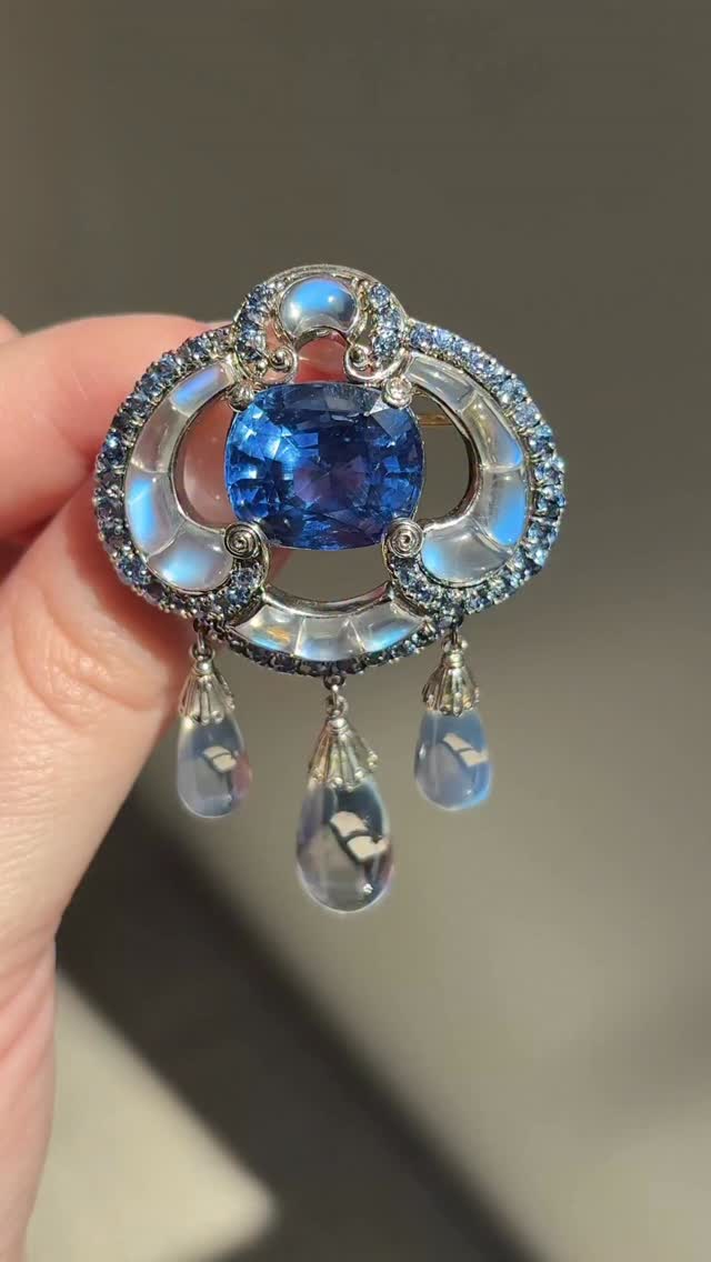 Light, color, exoticism and naturalism formed the core of Louis Comfort Tiffany’s (1848–1933) artistic vision. At the heart of Louis Comfort’s practice was a fascination with how materials could refract, diffuse, and transform light. His jewelry designs centered on color and luminosity with gemstones that were rarely embraced by mainstream American designers of the period. This shift in emphasis elevated the prominence of moonstone, opal, turquoise and other less conventional materials within his work. The relationship between color and illumination remained fundamental to his artistic production. In the present lot, translucent moonstones exemplify Louis Comfort’s attention to optical effects. Their adularescent glow softens the light passing through them while producing a cool, bluish shimmer that evokes a sense of mystery. Each stone is calibrated to follow the curve of the scroll motif, ending in delicate drop-shaped fringes. The accenting periwinkle-hued sapphires provide a vivid contrast to the moonstones’ cool glow, enriching the composition and guiding the viewer’s eye toward the central sapphire. Lot 132: AN IMPORTANT TIFFANY & CO., LOUIS COMFORT TIFFANY ANTIQUE SAPPHIRE AND MOONSTONE BROOCHEstimate: $80,000 – 120,000 Magnificent Jewels | New York | 9 June Join us this week to view Magnificent Jewels at Rockefeller Center!Friday 5 June – Monday 8 June | 10 am – 5pm #christies #christiesjewels #Tiffany #LouisComfortTiffany by @christiesjewels