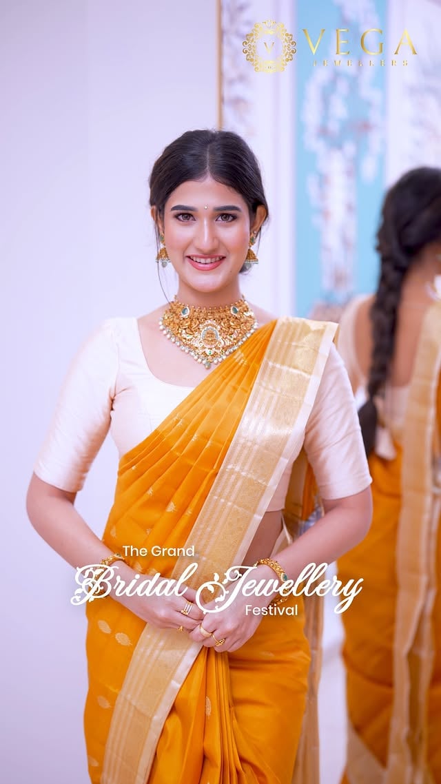 Pure Bridal Royalty: The Grand Nakshi Choker ✨👑Introducing a masterpiece of pure craftsmanship from our Grand Bridal Jewellery Festival—a Grand Golden Nakshi Choker Set designed to make your forever bridal memory unforgettable.👑 The Design DetailsThe Masterpiece: An intricately handcrafted South Indian Temple Choker featuring a prominent Lakshmi Devi Motif at the center, symbolizing prosperity, wealth, and timeless bridal elegance.The Artistry: Adorned with detailed Peacock Carvings and finished in a rich, regal Antique Polish for that authentic royal temple vibe.The Accents: Beautifully embedded with vibrant pink Kundan stones, deep emerald green highlights, and delicate pearl hangings.The Complete Look: Paired seamlessly with matching heritage Jhumkas and heavily detailed classic Bangles.✨ Experience the GrandeurStep into our nearest showroom to explore the ultimate bridal collections.📍 Locations: Vijayawada | Hyderabad | Kakinada | Eluru | Guntur🌐 Website: vegajewellers.com📞 Contact: +91 99899 43625#VegaJewellers #NakshiChoker #TempleJewellery #SouthIndianBride #BridalGoldJewellery #KanjeevaramSaree #GoldChokerSet #HyderabadBrides #VijayawadaShopping #AntiqueGoldJewelry #LakshmiNecklace #IndianWeddingJewelry #bridaljewelleryfestival by @vegajewellers_jubileehills